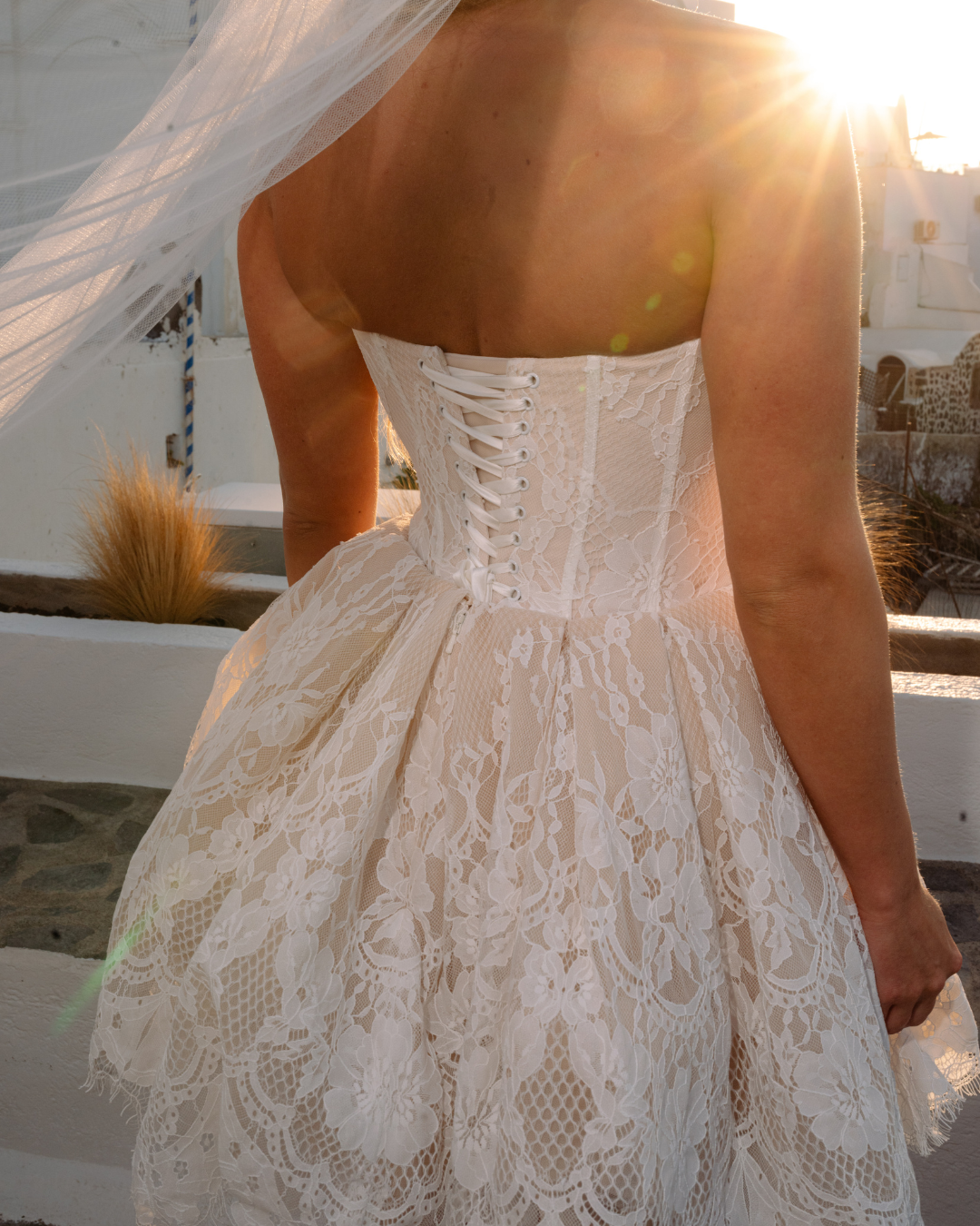 Bride wearing Athena Short Bridal Dress by Aurelle Attire in Santorini, perfect for destination weddings with romantic, airy design.